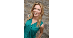 Blonde haired woman wearing green shirt smiling outside